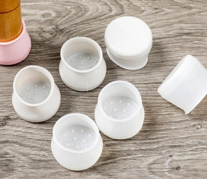 Detailed close-up of silicone furniture leg covers with anti-slip texture on wood floor