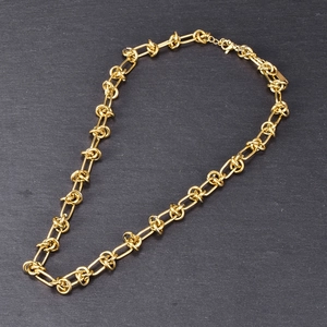 Macro detail of chunky 18K gold chain necklace with interlocking rectangular links