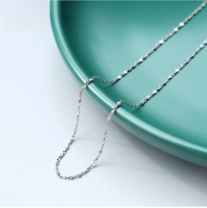 Macro detail of 1.1mm stainless steel star chain with polished silver metallic finish