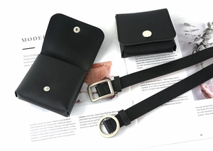 Flat lay of black leather waist belt with silver buckles and mini bag pouches