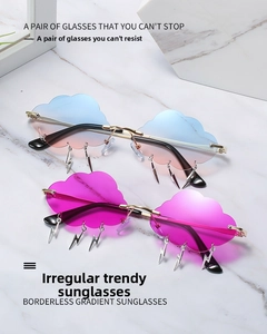 Close-up of cloud-shaped rimless gradient sunglasses with metallic lightning pendants