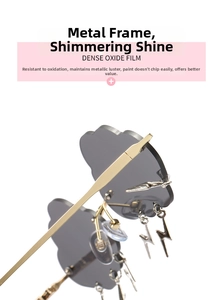 Detail of cloud-shaped sunglasses with gold frame and hanging lightning bolt charms