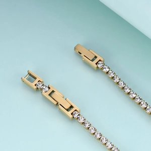 Detailed macro view of the gold double fold-over clasp and CZ tennis bracelet linkage