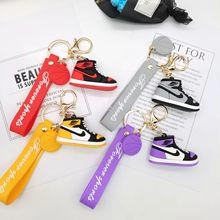 Dettaglio di mini portachiavi a forma di sneakers colorate con cinturini in gomma