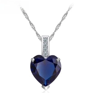 Detailed view of deep blue heart pendant necklace with shimmering zircon and silver chain