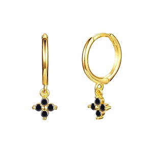 Detalle de pendientes de aro dorados con elegantes colgantes de trébol de cuatro hojas negros