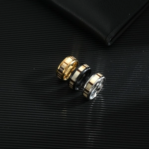 Men's fashion ring set in gold, black and silver with wood inlay on textured background