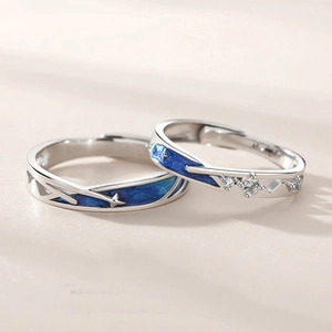 Macro shot of silver angel wing couple rings with blue star enamel and zircon stones