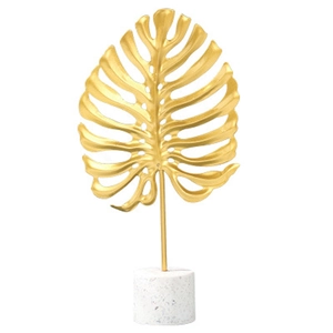 Nordic gold metal monstera leaf ornament with elegant white terrazzo base centerpiece