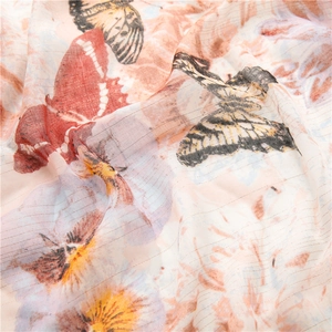 Elegant butterfly and floral print scarf with gold metallic thread in warm pink-orange tone