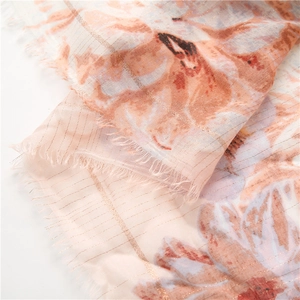 Detail of pink cotton-linen scarf with gold metallic threads and frayed edge texture