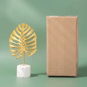 Nordic gold metal monstera leaf decor with marble base and packaging reference