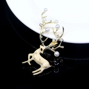 Detail of deer-shaped brooch with white pearls, crystals and beige enamel coating