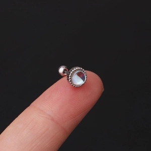 Macro view of round moonstone stud earring with textured silver base and screw ball back