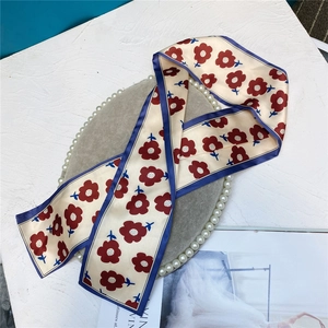 Detailed macro view of cream floral satin ribbon with navy trim on a display tray