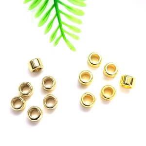 Golden hollow cylinder spacer beads for DIY jewelry making on a minimalist white background