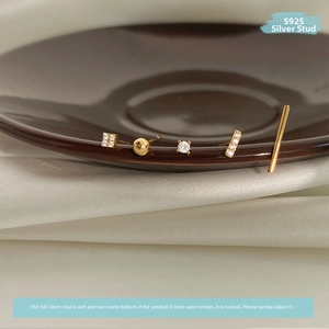 Detail of 5-piece gold earring set with S925 silver needles and zircon on ceramic plate