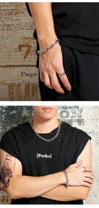 Detailed view of silver stainless steel chain necklace and bracelet set on a model