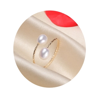 Gold filled spiral ring with two white freshwater pearls on champagne silk background