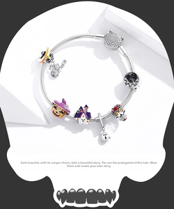 Macro detail of S925 sterling silver Halloween pumpkin and skull charms on snake chain