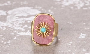Detail of pink natural stone ring with golden sun motif and turquoise center bead