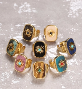 Detail of adjustable gold rings with natural stones featuring a sunburst motif