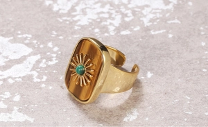 Detailed shot of adjustable gold flower ring with tiger eye stone and green accent