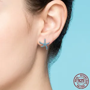 S925 sterling silver starfish stud earrings with blue zirconias on female model