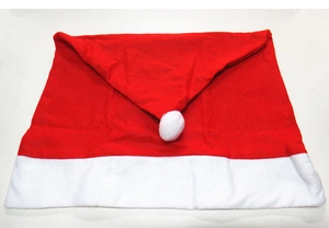 Detail of red and white plush Santa hat chair back cover with white pom-pom on white background