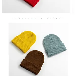 Detailed close-up of colorful ribbed knit beanies in mustard, blue, brown, and red colors