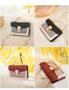 Detail showing stars pattern on transparent square bag with gold chain strap and buckle