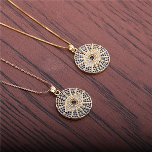 Gold plated evil eye necklace with blue cubic zirconia on dark wood background