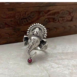Vintage silver Ganesha elephant ring with red gemstone on stone surface