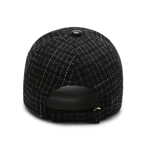 Back view of black tweed baseball cap with adjustable strap and golden metal ring