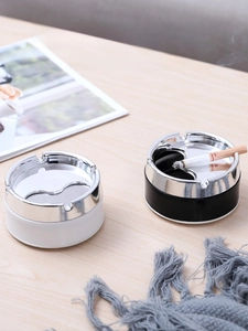Macro shot of windproof rotating sealed ashtrays in black and white on a wooden table