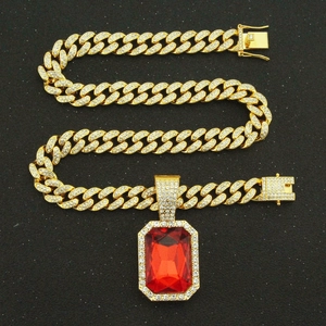 Luxurious gold Cuban chain necklace featuring a large red ruby pendant and sparkling diamonds