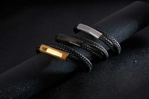 Detailed macro view of woven leather bracelets with polished gold, silver and black metal plates
