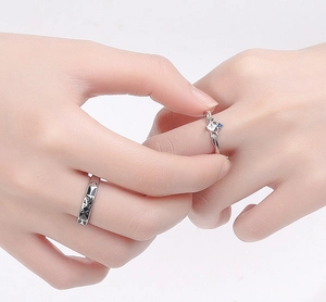 Close-up of crown and cutout design couple rings with blue and white stones