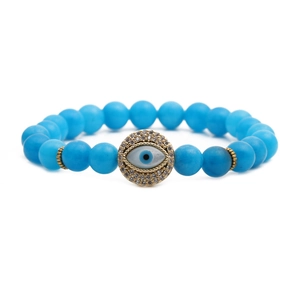 Macro detail of sky blue matte beads and gold Evil Eye charm with sparkling crystals