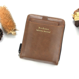Detailed view of brown leather wallet with external card slot and metal zipper closure