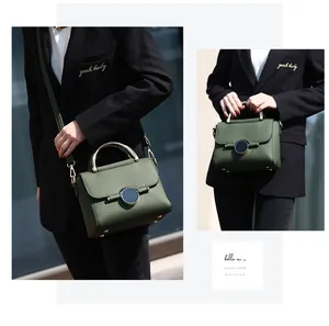 Macro detail of dark green textured leather bag with gold handle and black buckle