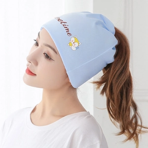 Detail view of light blue ponytail beanie hat showing functional rear opening on a model