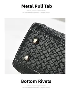 Detail view of the black woven leather texture and silver metal rivets on the handbag base