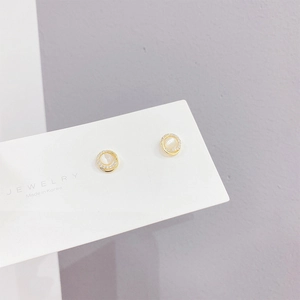Detailed macro view of S925 silver needle stud earrings with gold plating and white stone
