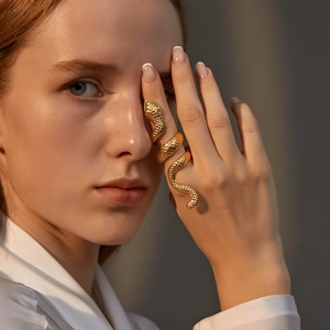 Detailed view of golden snake-shaped spiral ring with intricate scale textures on a model
