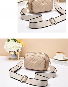 Detail of beige quilted crossbody bag featuring gold M logo and wide fabric strap