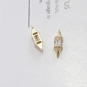 Vista macro di ciondolo geometrico per nail art placcato oro con zirconi incastonati
