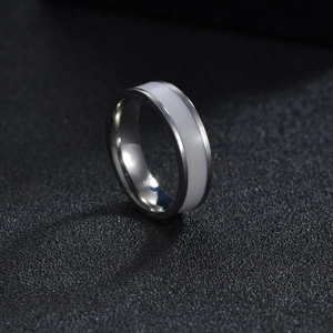 Macro shot of polished silver titanium steel ring with a smooth white enamel inlay