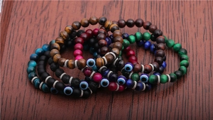 Detailed close-up of colorful 8mm tiger eye bead bracelets with blue evil eye charms
