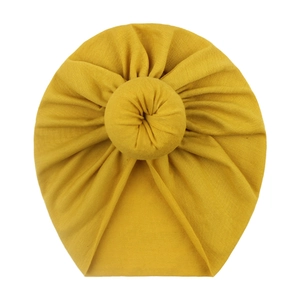 Soft yellow baby turban hat with decorative top knot design for infants and toddlers
